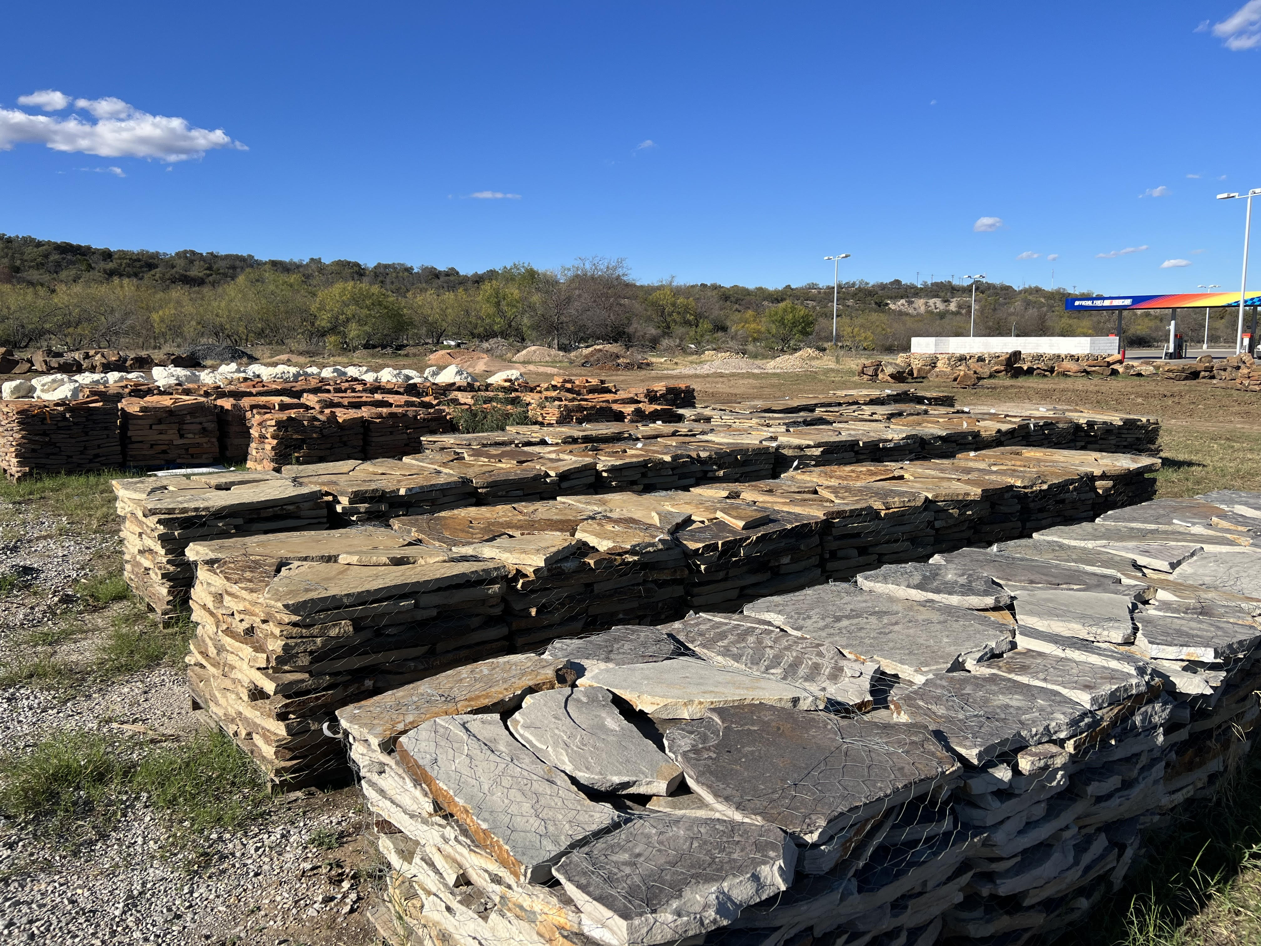 Pallets of flagstone patio stone and white boulders at the Brownwood, TX landscape rock yard