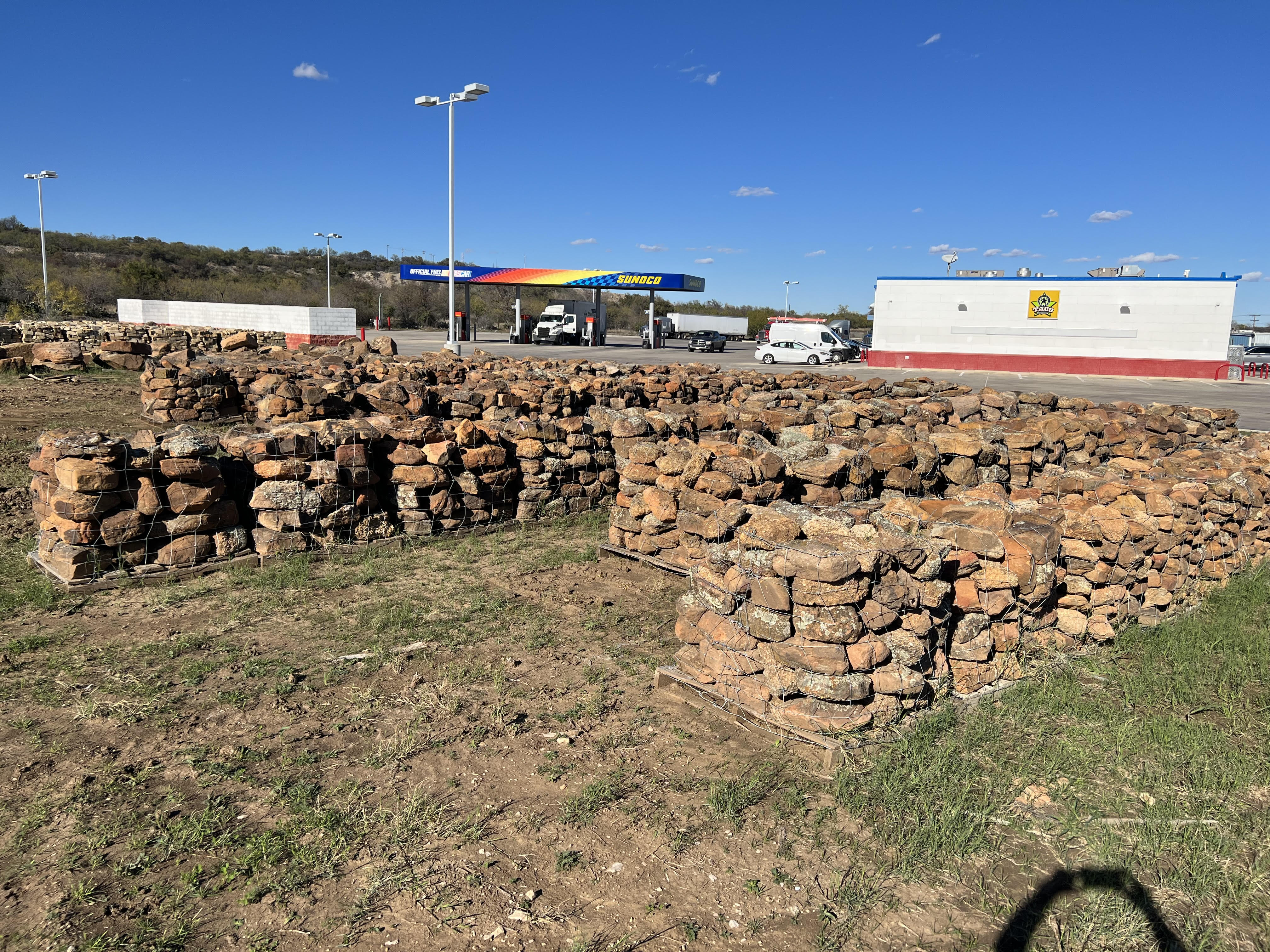 Stacked pallets of landscape rock and stone near the road frontage of Trees Forever Nursery in Brownwood, TX