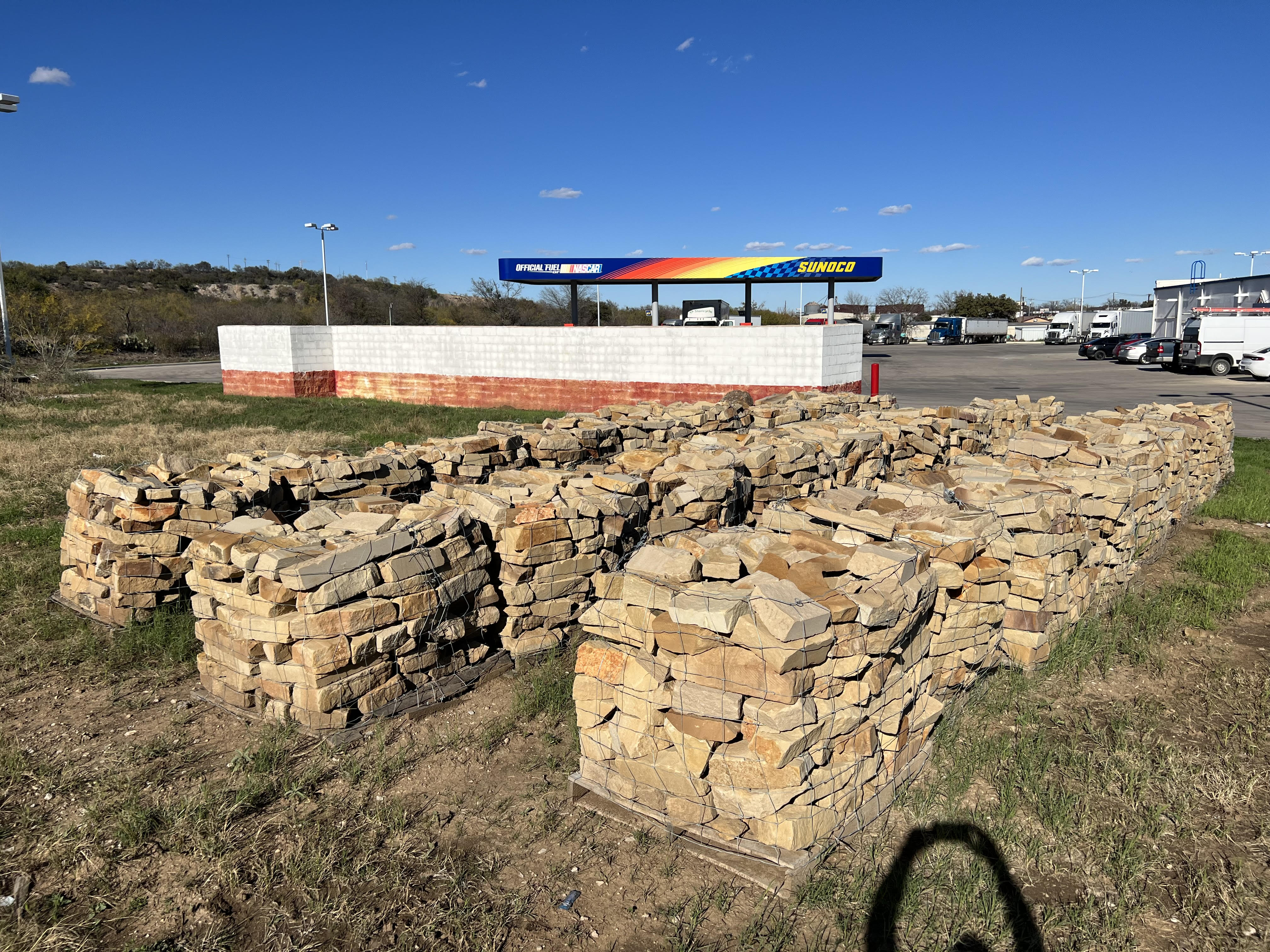 Rows of stacked landscape stone and rock pallets in the Trees Forever Nursery supply yard in Brownwood, TX